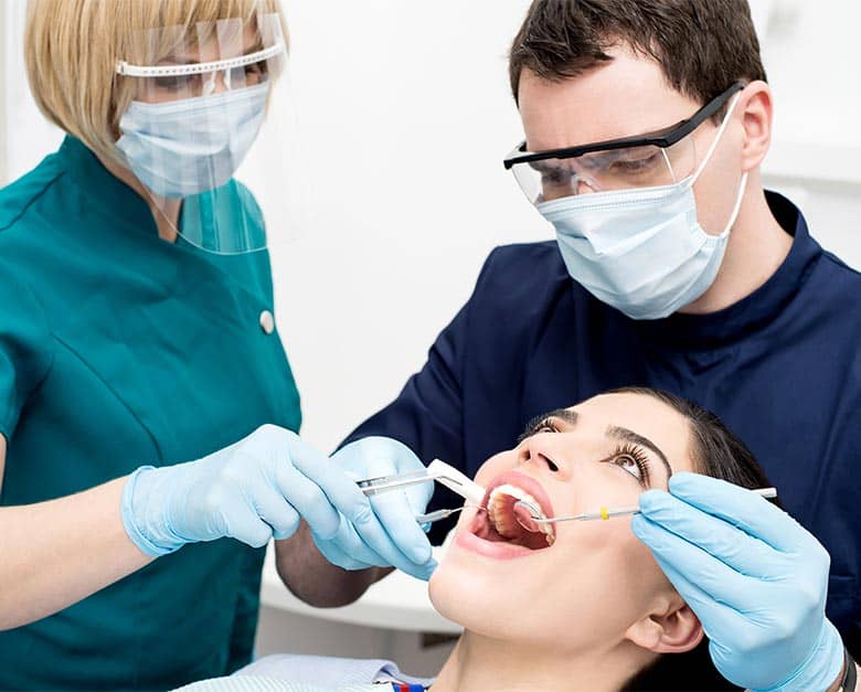 denstist examining teeth and gums