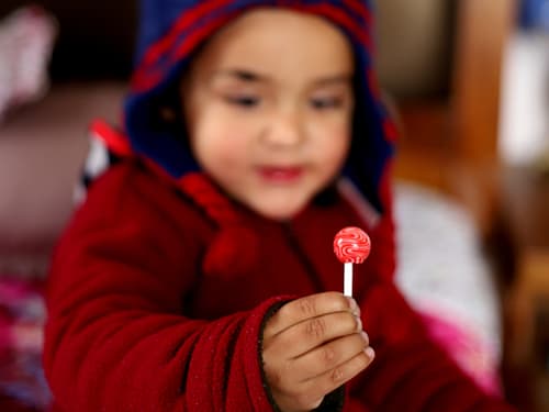 boy holding a red lollipop