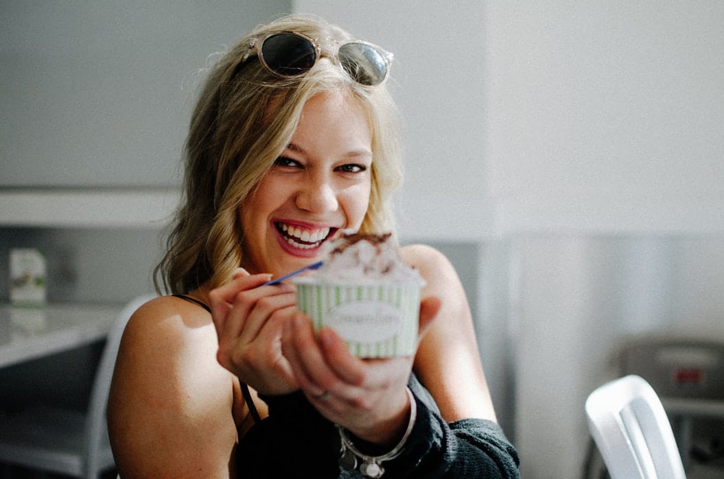portrait of a young woman smiling and eating ice cream