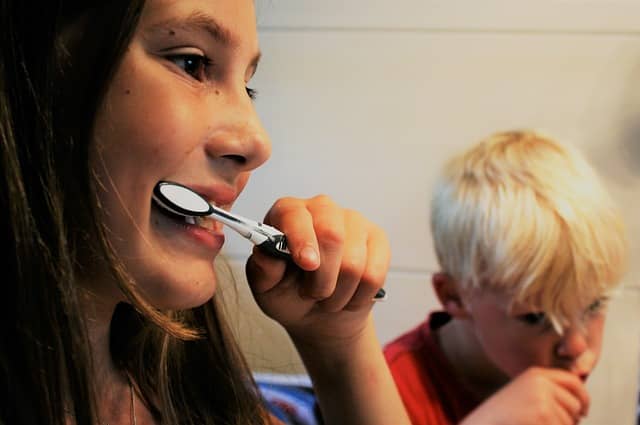 girl and boy brushing their teeth