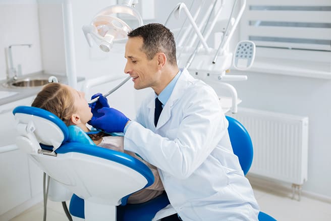 Positive cheerful doctor sitting near the patient