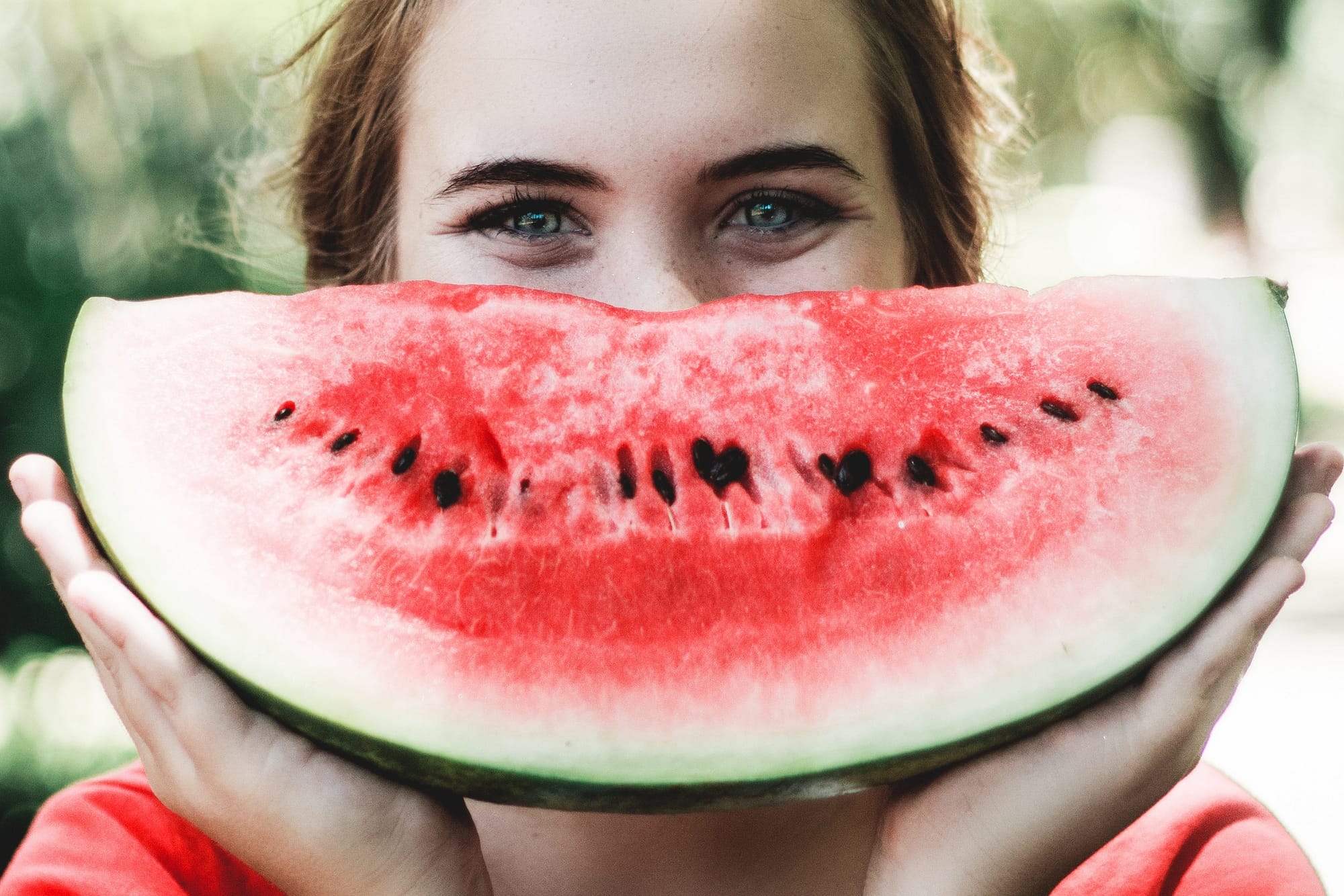 Happy young woman holding a watermelon slice