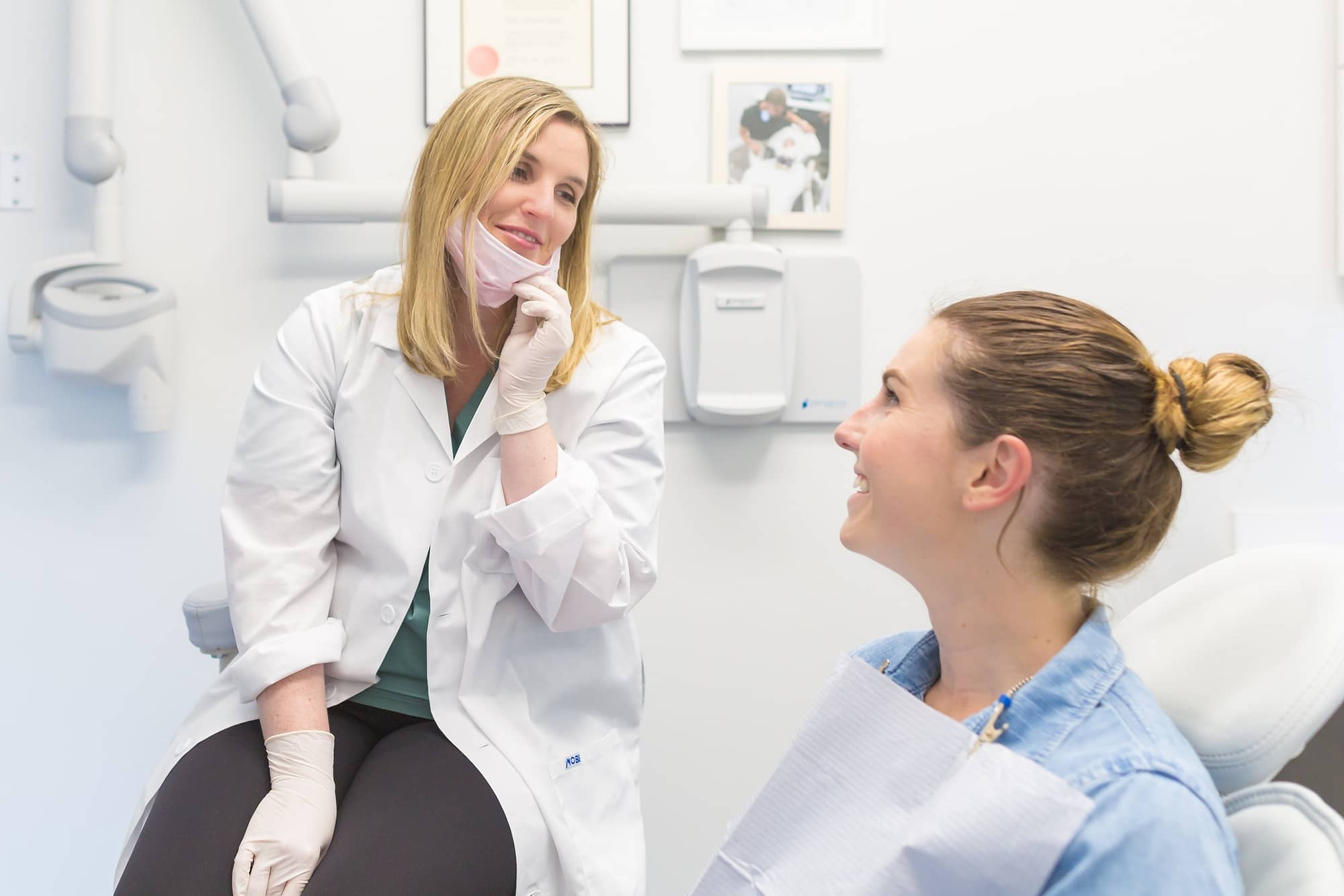 Female oral health therapist talking to young female patient
