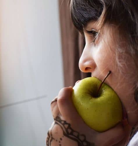 child eating a green apple